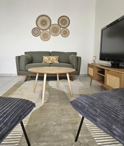sala de estar con sofá y mesa en Superbe Apt 2 ch, terrasse, WIFI, parking gratuit, en Toulouse