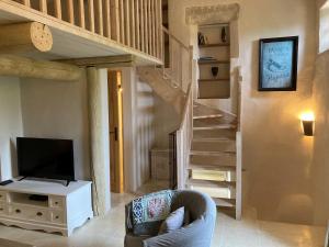 uma sala de estar com uma escada e uma televisão em Château de la Merletade em Cheval-Blanc