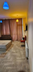 a bedroom with a bed and a chair and a desk at HOTEL PERLA DE MAR in Makhinjauri