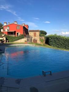een groot zwembad met blauw water voor een huis bij Il Conte, Alloggio romantico per Coppie + Piscina in Serravalle Pistoiese