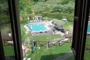 een raam met uitzicht op een zwembad bij Il Conte, Alloggio romantico per Coppie + Piscina in Serravalle Pistoiese