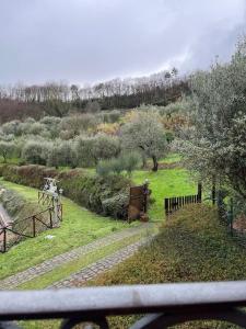 uitzicht op een tuin met bomen en een hek bij Il Conte, Alloggio romantico per Coppie + Piscina in Serravalle Pistoiese