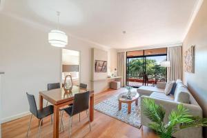 a living room with a couch and a table at Two Adjacent King Suites with a Breezy Balcony in Darwin