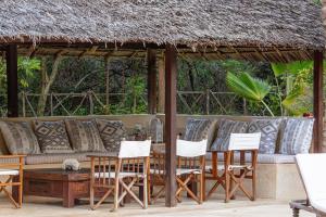 grupa krzeseł i kanapa na patio w obiekcie Pepo Villa, Anasa Hotels & Experiences w mieście Lamu