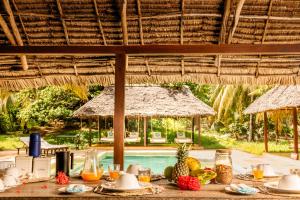 uma mesa com comida e fruta sobre ela num pavilhão em Pepo Villa, Anasa Hotels & Experiences em Lamu