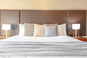 Letto o letti in una camera di Two Adjacent King Suites with a Breezy Balcony