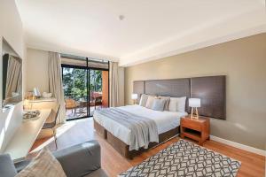 una camera da letto con un letto grande e un balcone di Two Adjacent King Suites with a Breezy Balcony a Darwin