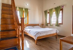 um quarto com uma cama e uma escada com cortinas verdes em Sundew-n-Lake em Nainital