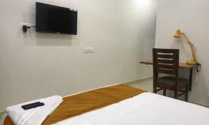 1 dormitorio con 1 cama y TV en la pared en FabHotel Rithik Heights Hitech City, en Hyderabad
