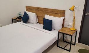 1 dormitorio con 1 cama con almohadas azules y lámpara en FabHotel Rithik Heights Hitech City, en Hyderabad