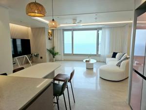 ein Wohnzimmer mit einem weißen Sofa und einem weißen Tisch in der Unterkunft Sokcho Sea Pureun 35 in Sokcho