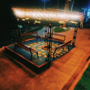 a group of benches on a patio at night at MANNATH POOL VILLA in Kozhikode