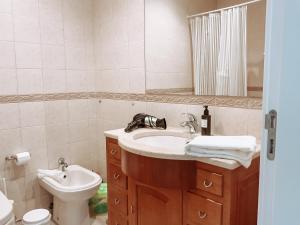 a bathroom with a sink and a toilet and a mirror at Dani's House - Nazaré in Nazaré +15 photos