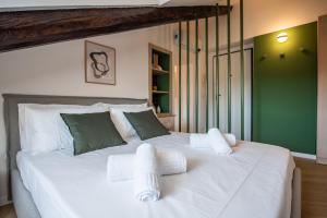 a bedroom with a large white bed with green walls at Turin Sky House City Center in Turin