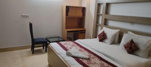 Friends Residency في نيودلهي: غرفة نوم بسرير وكرسي ومكتب