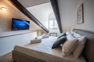 a bedroom with a bed with a tv on the wall at Turin Sky House City Center in Turin