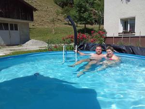 a man and a child in a swimming pool at Domačija Markc in Železniki