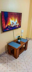 a living room with a table with a fireplace at 2 Bedroom at Kamakis near Greenspot Long term 5 days plus in Ruiru