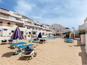 a resort with a pool and people sitting on lounge chairs at Port Royale 291, Spacious Studio in Los Cristianos