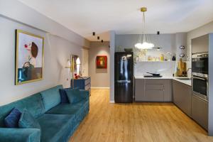 ein Wohnzimmer mit einem blauen Sofa und einer Küche in der Unterkunft Five Seasons Alimos in Athen