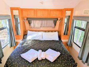 una camera da letto con un letto con due asciugamani sopra di Cypress Caravan Stay a Emerald