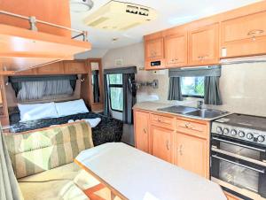 una cucina con camper, divano e lavandino di Cypress Caravan Stay a Emerald