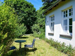 una mesa y sillas junto a una casa en Ferienwohnung Alte Dorfschule, en Lüssow