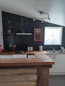 ニューノーフォークにあるOld Colony Innのキッチン(木製のカウンタートップ、窓付)