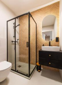 ein Bad mit einer Dusche, einem WC und einem Waschbecken in der Unterkunft Trevilles Apartamenty Soft Loft in Szklarska Poręba