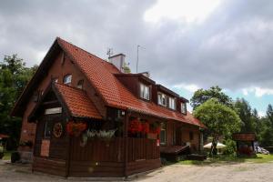 uma casa com um telhado laranja e flores nela em Bajkowy Zakątek em Gietrzwałd