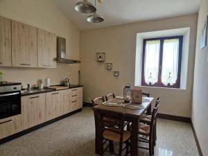a kitchen with a table and chairs in a room at Agriturismo Rossello in San Quirico dʼOrcia