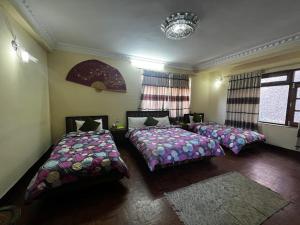 a bedroom with two beds and a chandelier at Eco Resort in Dhulikhel