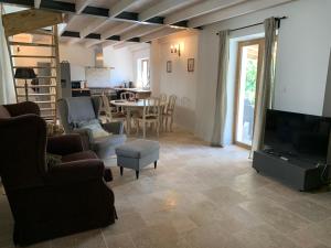 a living room with a television and a table with chairs at Les Séchoirs in Clairac