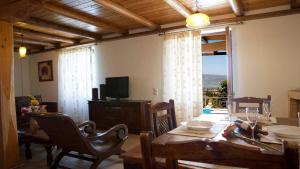 a living room with a dining table and a television at Theasis Villas in Lygia