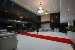 a large lobby with a red carpet and couches at Royal Bliss in Patna