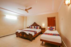 um quarto com 2 camas e uma ventoinha de tecto em FabHotel Maruthi Residency em Hyderabad