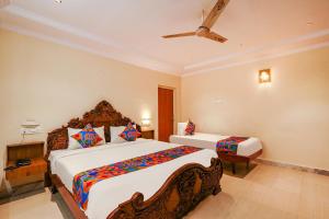 a bedroom with two beds and a ceiling fan at FabHotel Maruthi Residency in Hyderabad