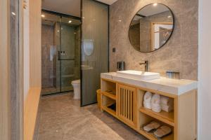 uma casa de banho com um lavatório e um espelho em Rivulet Mountain Hotel - Zhangjiajie Forest Park Scenic Area em Zhangjiajie