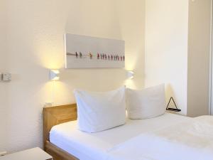 ツィングストにあるResidenz am Strand, Whg 238のベッドルーム1室(白い枕のベッド1台付)、壁に絵画が備わります。