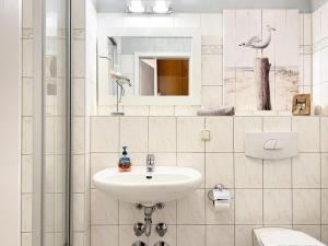 La salle de bains blanche est pourvue d'un lavabo et de toilettes. dans l'établissement Residenz am Strand, Whg 238, à Zingst