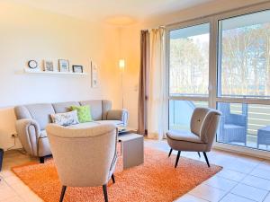 - un salon avec un canapé et deux chaises dans l'établissement Residenz am Strand, Whg 238, à Zingst