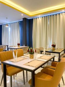 ZARA HOTEL في أنتاناناريفو: غرفة طعام مع طاولات وكراسي صفراء