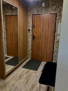 Cette chambre dispose de deux portes en bois et d'un miroir. dans l'établissement Kameralny Apartament z Balkonem, à Szczytno
