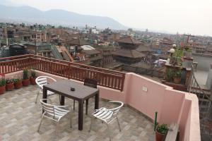 uma mesa e cadeiras numa varanda com vista para a cidade em Jhigu Chhen em Bhaktapur