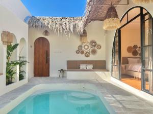 een binnenzwembad in een huis met een slaapkamer bij Tujuan Jogja Villas With Private Pool in Jetis