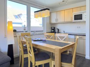 eine Küche mit einem Holztisch und Stühlen im Zimmer in der Unterkunft Residenz am Strand, Whg 355 in Zingst
