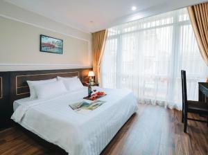 Un dormitorio con una gran cama blanca y una ventana en Lake View Hotel & Travel, en Hanói