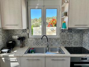 uma cozinha com um lavatório e duas janelas em Vrachos Luxury Home 3, private pool! em Agía Galíni