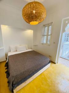 - une chambre avec un lit et un lustre dans l'établissement New private Riad Fiora, à Marrakech