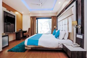 um quarto com uma cama grande e almofadas azuis em Green Valley Resort Mashobra By AN Hotels em Shimla